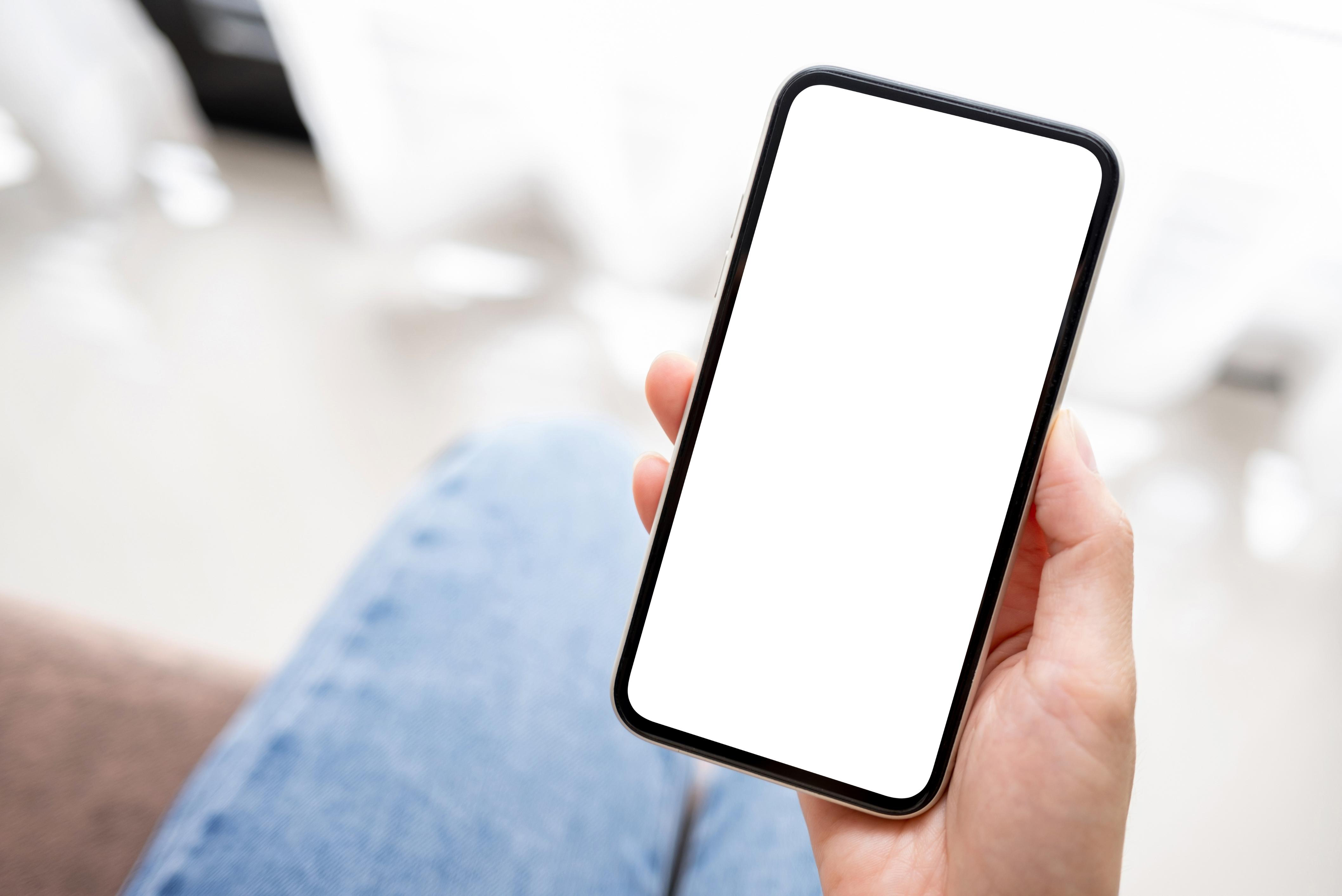 A hand holding a phone displaying the OnSiteDocs Safety Monitor
