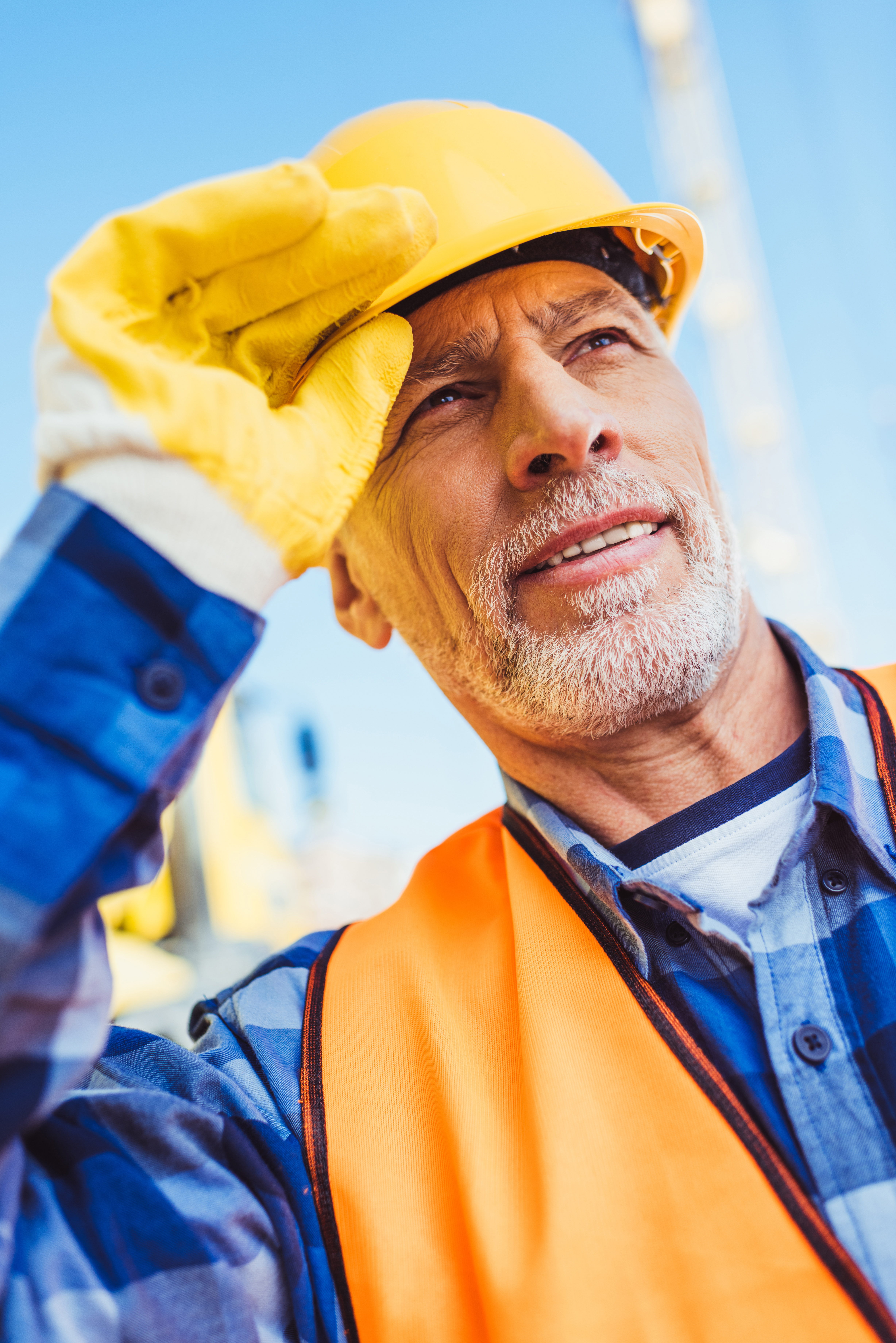 Construction worker adjusting a hard hat on a jobsite